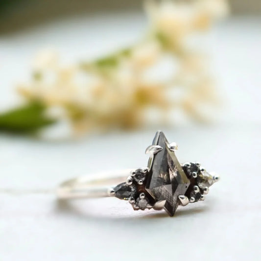 Kite Cut Diamond Cluster Ring Contemporary Bridal Design featuring a 1.15 CT kite cut salt and pepper diamond in a cluster setting with round black side stones and pear shaped accent stones in a contemporary engagement ring style.
