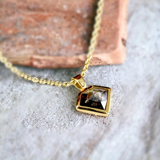 Shield Shaped Salt and Pepper Diamond Pendant features a shield-shaped pendant showcasing a natural grey salt-and-pepper diamond with a soft, elegant appeal. The design highlights a delicate chain and handcrafted artisan styling with a refined, minimalist look suitable for everyday wear.
