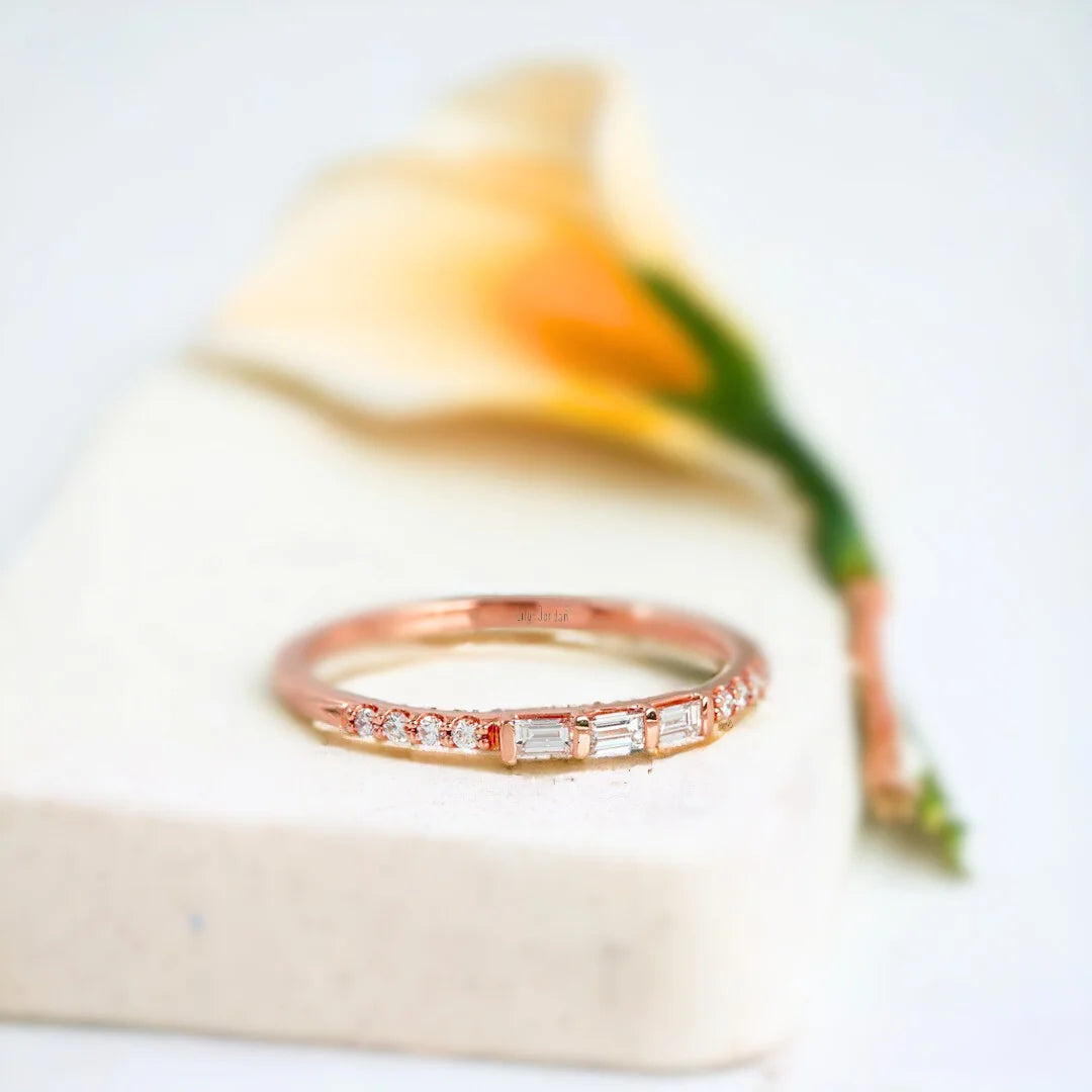 Baguette Diamond Band Primrose Stackable Baguette Ring featuring a natural white diamond center stone with a baguette-cut diamond design, a slim solid gold band, and round side diamonds in a modern minimalist stackable ring style.