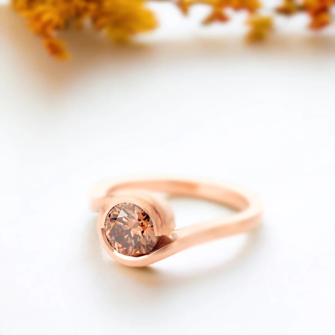 Brown Diamond Ring Fairtrade Rose Gold Wave Cognac Diamond Ring showing a rose gold wave-style bypass ring with a round-cut brown diamond in a sculptural handcrafted design
