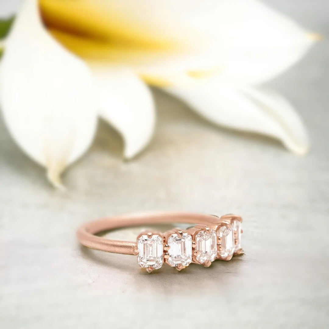 Emerald Diamond Ring Five-Stone Design featuring five natural emerald-cut diamonds in a structured linear arrangement on a straight shank band with an organically layered design and a modern, elegant ring style.