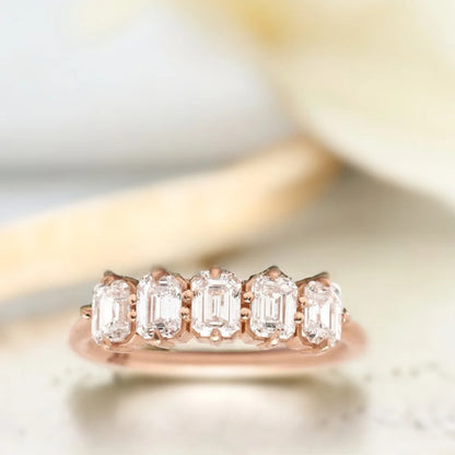 Emerald Diamond Ring Five-Stone Design featuring five natural emerald-cut diamonds in a structured linear arrangement on a straight shank band with an organically layered design and a modern, elegant ring style.