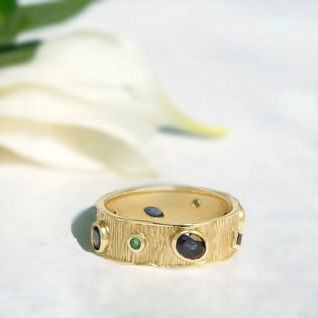 Handcrafted Multicolour Gemstone Ring Blue Green Sapphire Band showing a multicolour gemstone ring with natural blue and green stones in oval and round cuts set on a bold straight 7.00mm band with handcrafted contemporary design