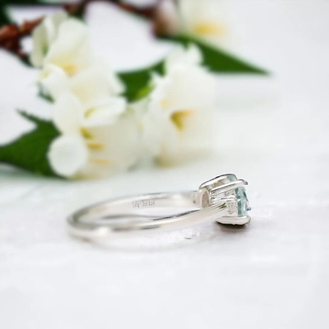 Lab-Created Diamond Aquamarine Trilogy Ring Engagement Design featuring a round 1.15 Ct aquamarine centre stone with a vibrant blue hue, flanked by lab-created white diamond side stones in a balanced trilogy setting with a slim straight shank design.