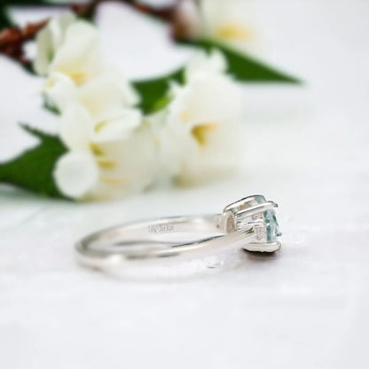Lab-Created Diamond Aquamarine Trilogy Ring Engagement Design featuring a round 1.15 Ct aquamarine centre stone with a vibrant blue hue, flanked by lab-created white diamond side stones in a balanced trilogy setting with a slim straight shank design.
