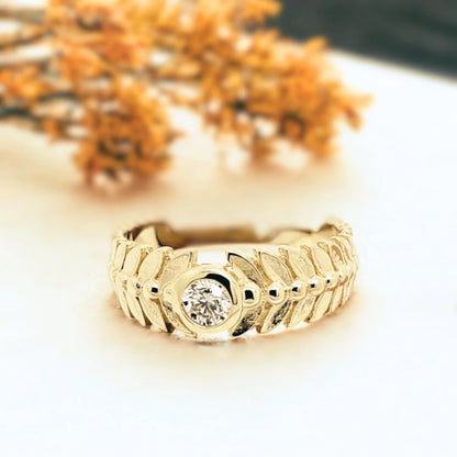 Leaf-inspired White Diamond Engagement Ring Marquise Bezel Diamond Ring featuring a round-cut white diamond set in a gold-tone band with leaf-patterned detailing, wide tapered structure, and clean bezel style influence
