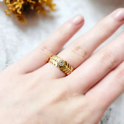Leaf-inspired White Diamond Engagement Ring Marquise Bezel Diamond Ring featuring a round-cut white diamond set in a gold-tone band with leaf-patterned detailing, wide tapered structure, and clean bezel style influence
