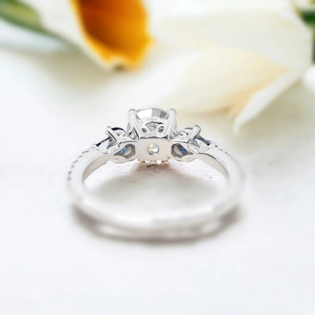 Milky Way Diamond Ring Mossy Glen Engagement Ring Statement Ring featuring a round salt-and-pepper diamond center stone with soft milky grey tones, accented by blue marquise and round gemstones in a slim modern engagement ring design