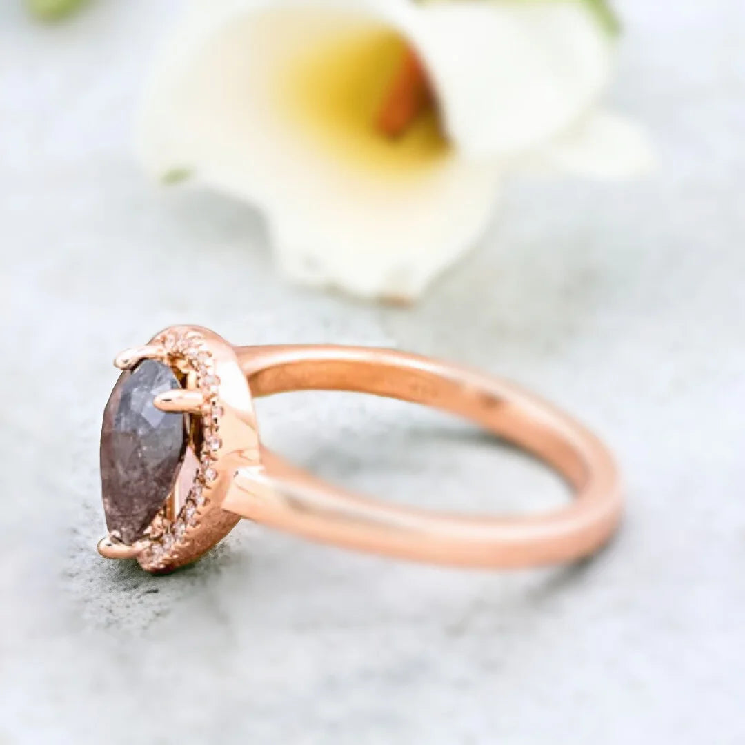 Natural Salt and Pepper Diamond Ring With Pear Cut Pavé Engagement Style showcasing a pear-cut natural salt and pepper diamond center stone with organic inclusions, surrounded by round pavé diamond accents on a straight shank engagement style band, crafted in white gold, rose gold and platinum options with a modern, elegant handcrafted finish and fine jewelry appeal.
