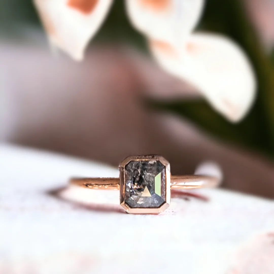 Natural Salt and Pepper Diamond Ring with Emerald Cut Design featuring a 0.84 CT emerald cut salt and pepper diamond in a modern minimalist ring style with a straight shank band and clean geometric silhouette.