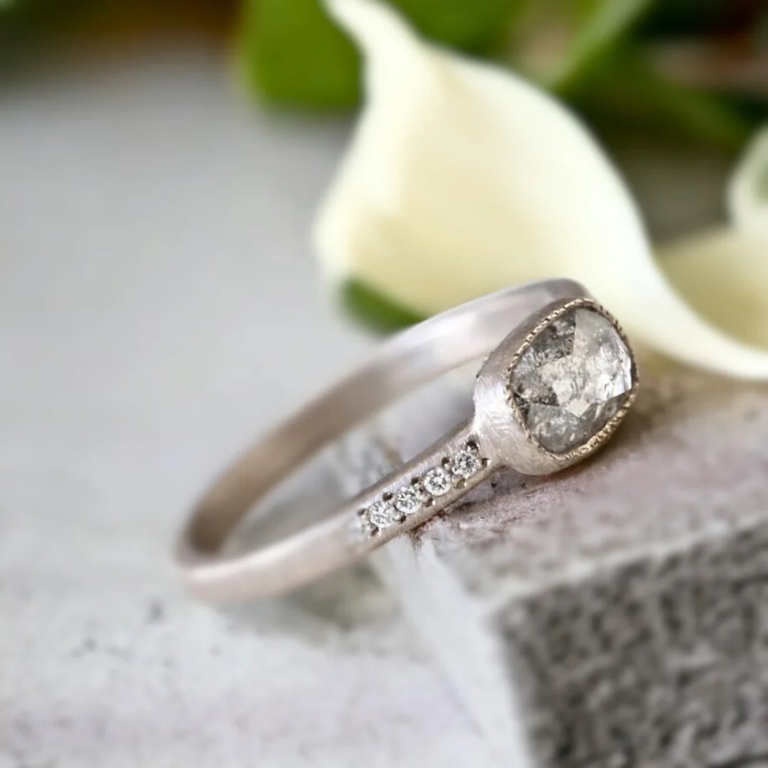 Natural Salt and Pepper Diamond Ring East-West Cushion Floating Bezel featuring a rose cushion-cut salt-and-pepper diamond in an east-west floating bezel setting with a straight shank and round diamond side stones.