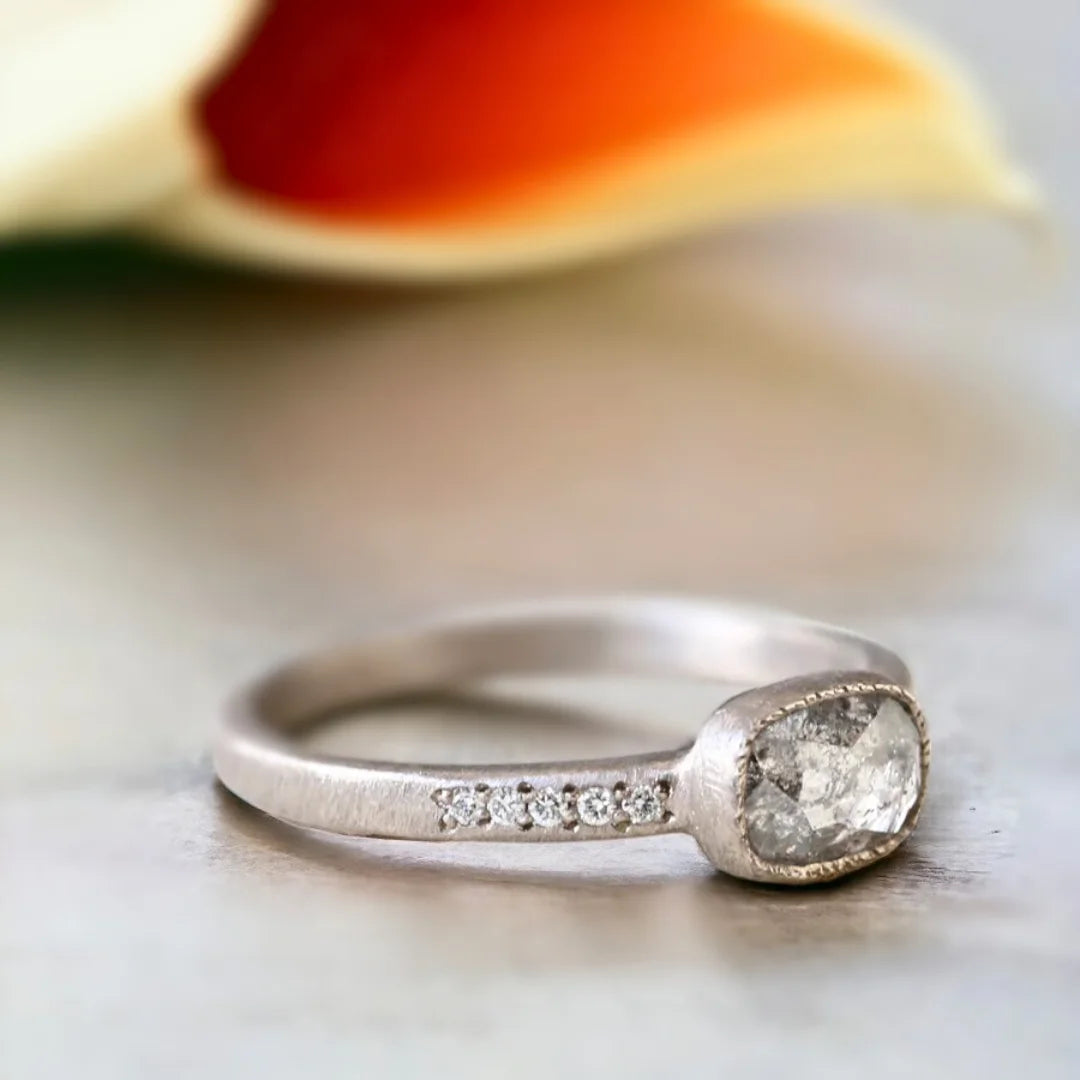 Natural Salt and Pepper Diamond Ring East-West Cushion Floating Bezel featuring a rose cushion-cut salt-and-pepper diamond in an east-west floating bezel setting with a straight shank and round diamond side stones.