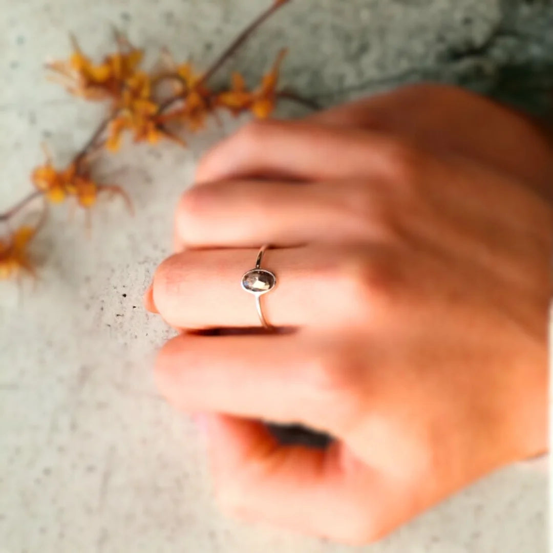 Oval Salt And Pepper Diamond Bezel Ring In White Gold featuring a 1.17 CT rose oval cut salt and pepper diamond in a white gold bezel setting with a minimalist engagement ring design and straight shank band.