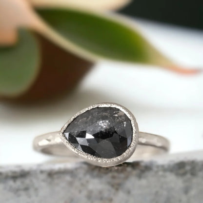 Pear-Shaped Salt-and-Pepper Diamond Ring In A Bezel Setting featuring a rose pear-cut salt-and-pepper diamond in a bezel setting with an organic layered band design and elegant handcrafted details.