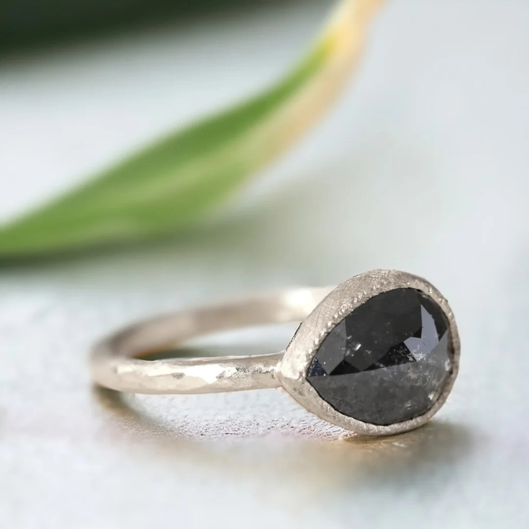 Pear-Shaped Salt-and-Pepper Diamond Ring In A Bezel Setting featuring a rose pear-cut salt-and-pepper diamond in a bezel setting with an organic layered band design and elegant handcrafted details.