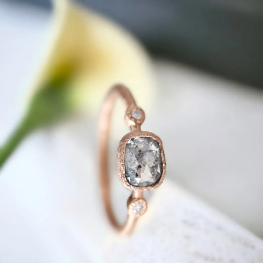 Rose Cushion Salt and Pepper Diamond Ring with Side Diamonds featuring a rose cushion-cut salt-and-pepper diamond center stone, round side diamonds, straight shank band, and handcrafted engagement ring design.