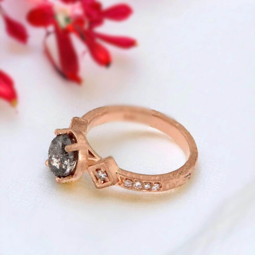 Rose Gold Salt and Pepper Diamond Ring with Oval Centre featuring an oval salt and pepper diamond centre stone in a rose gold setting with round side diamonds and a split-shank band design