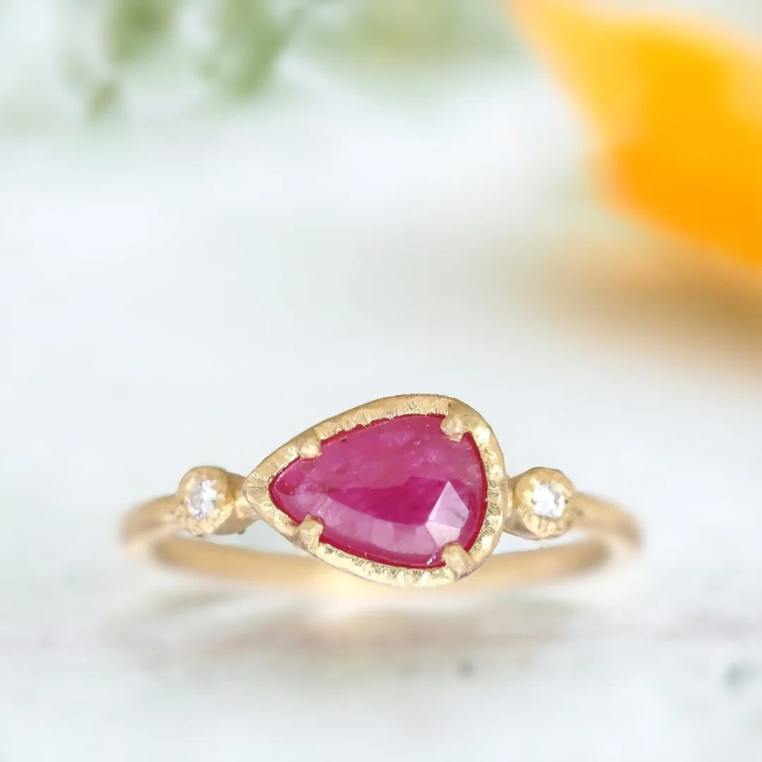 Rose Pear Ruby Diamond Ring with Side Diamonds featuring a rose pear-cut ruby center stone with round diamond accents, straight shank band, and elegant statement ring design.