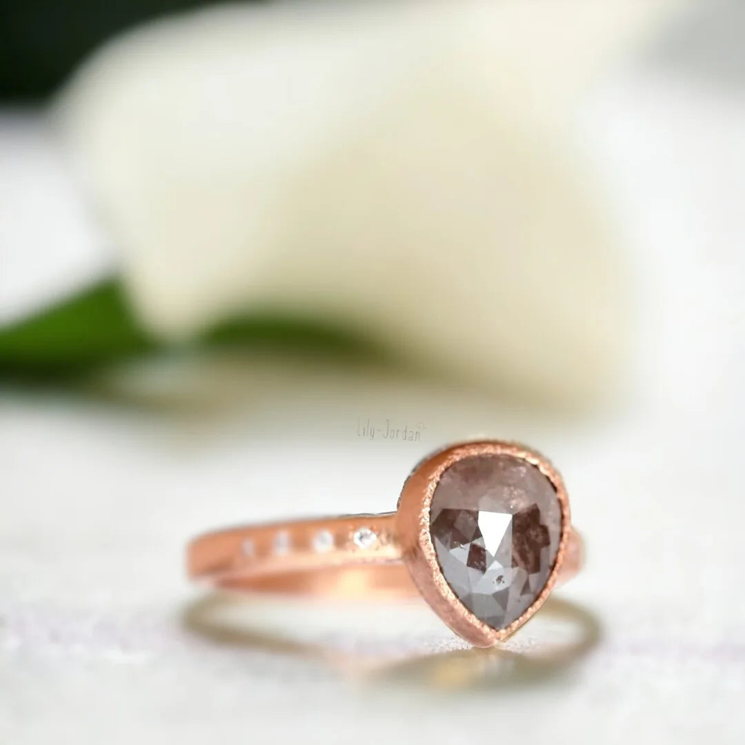 Rose Pear Salt and Pepper Diamond Ring with 2.70 CT Stone featuring a rose pear-cut salt-and-pepper diamond center stone, round side diamonds, straight shank band, and handcrafted artisan ring design with a textured organic finish.