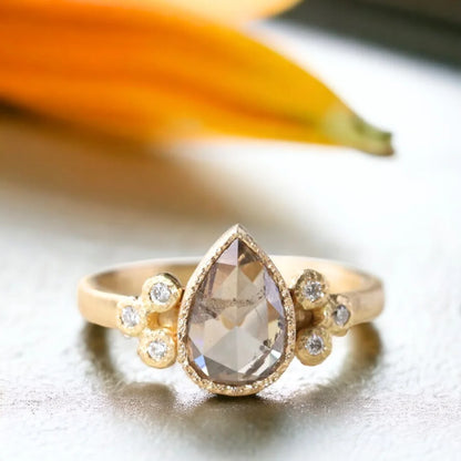 Rose Pear Salt and Pepper Diamond Ring Frosted Flame Diamond Ring featuring a rose pear-cut salt-and-pepper center diamond with a soft curved pear silhouette, round side diamonds, straight band design, and elegant handcrafted detailing with organic textured finish and ethical craftsmanship.