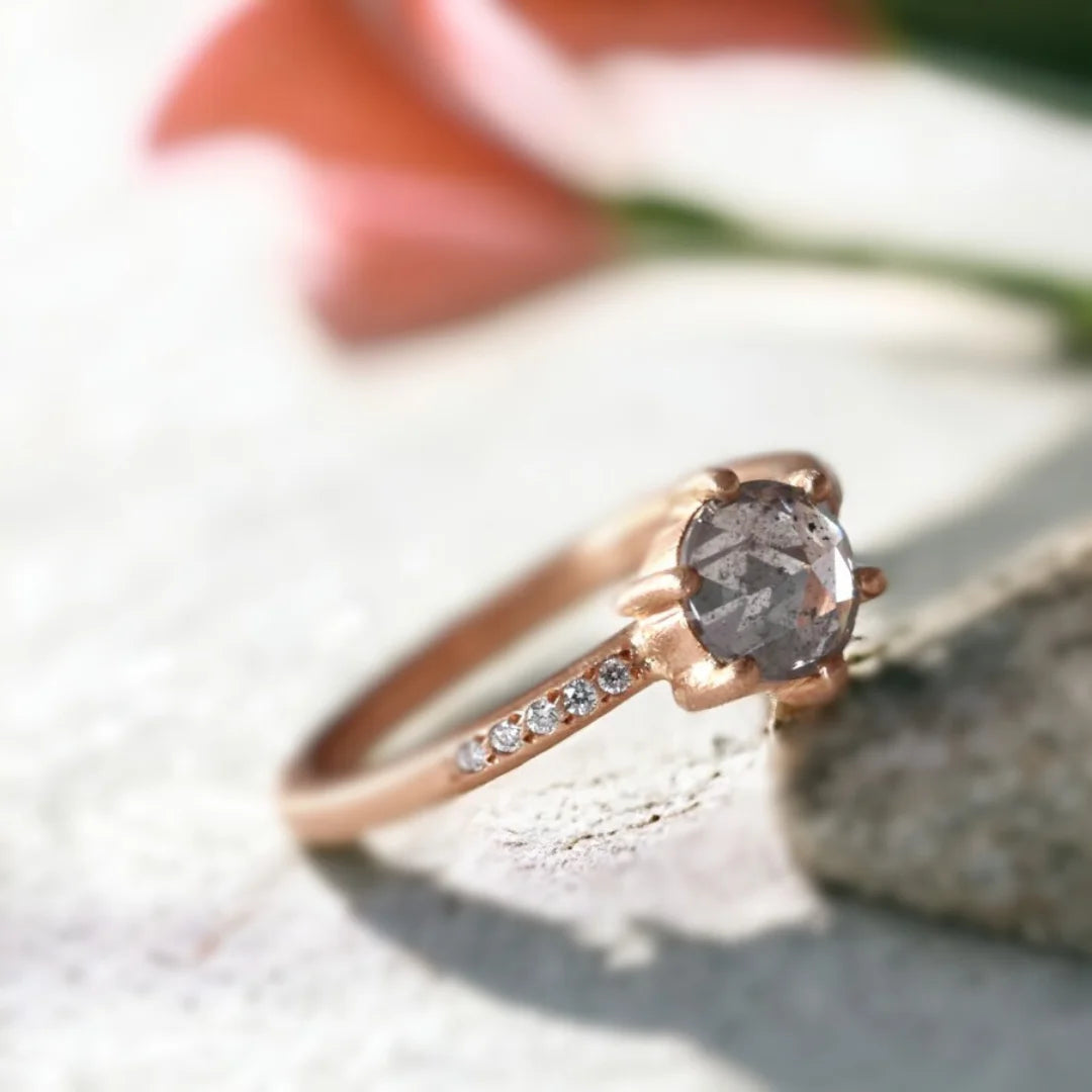 Round Rose Cut Salt And Pepper Diamond Ring With White Accent Diamonds featuring a round rose cut salt and pepper diamond center stone with white round accent diamonds, a straight shank ring design, and a handcrafted textured band with organic detailing.