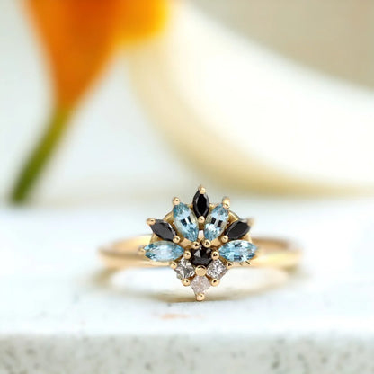 Salt and Pepper Cluster Diamond Ring Marquise Aquamarine Engagement featuring a cluster design with salt and pepper diamonds, black diamonds, and a light blue sapphire in mixed marquise, princess, and round cuts set in a slim, minimalist band