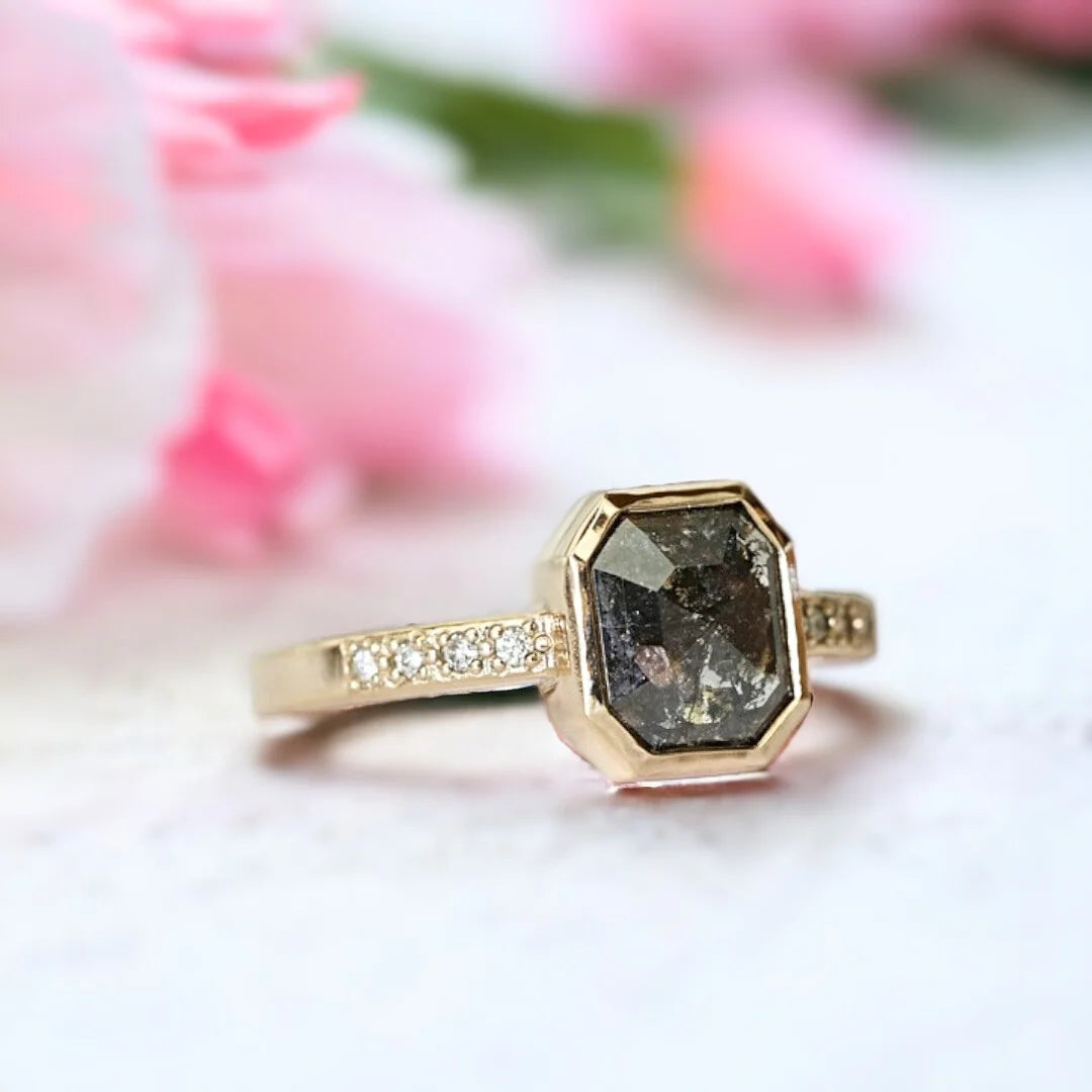 Salt and Pepper Diamond Anniversary Ring, Emerald Cut Milestone Ring featuring an emerald-cut natural salt-and-pepper diamond with round-cut side diamonds set in a slim straight band design with a minimalist and elegant milestone ring style