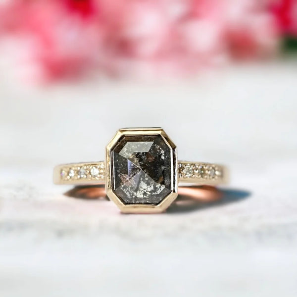 Salt and Pepper Diamond Anniversary Ring, Emerald Cut Milestone Ring featuring an emerald-cut natural salt-and-pepper diamond with round-cut side diamonds set in a slim straight band design with a minimalist and elegant milestone ring style