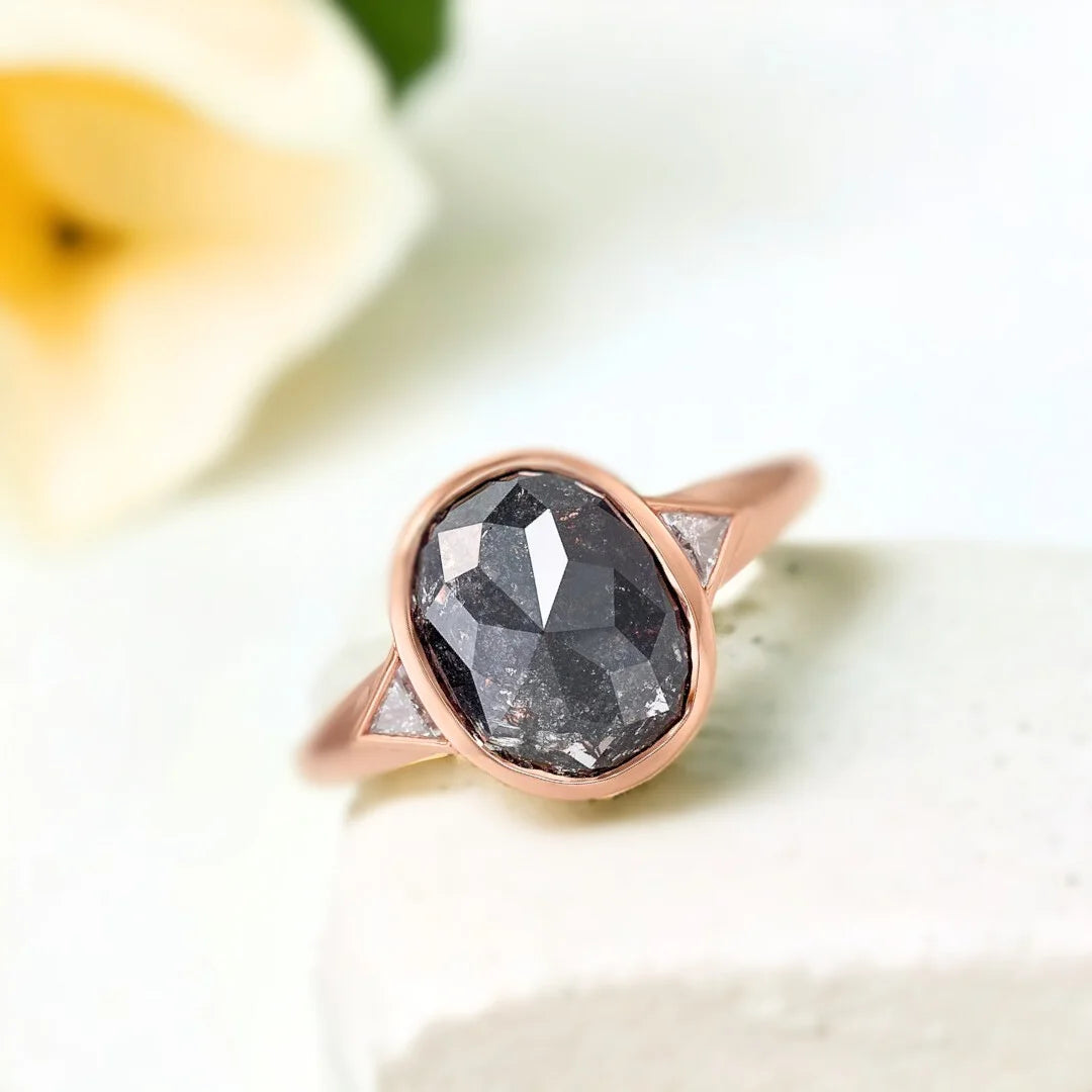 Salt and Pepper Diamond Engagement Ring featuring a rose cushion-cut 2.32 CT diamond with organic inclusions, grey triangle side stones, and a split shank design in a modern engagement ring style.