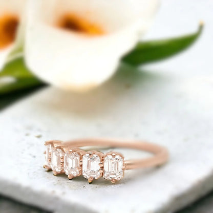 Emerald Diamond Ring Five-Stone Design featuring five natural emerald-cut diamonds in a structured linear arrangement on a straight shank band with an organically layered design and a modern, elegant ring style.