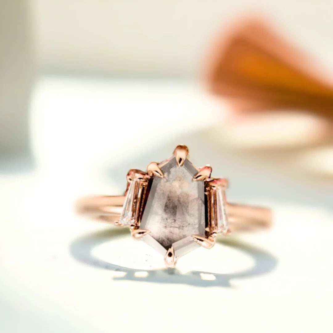 Shield Salt and Pepper Diamond Ring with 1.10 CT shield-cut stone featuring a shield-cut salt and pepper diamond with natural inclusions, baguette side diamonds, a minimalist geometric setting, and a straight shank band in a contemporary engagement ring design.