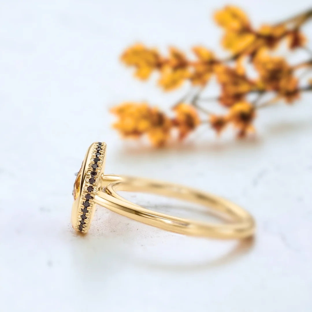 Yellow Sapphire Jubilee Ring with Black Accents and Artisan Design featuring a round Jubilee-cut yellow sapphire, black accent stones, gold ring setting, straight shank band, and handcrafted artisan styling.