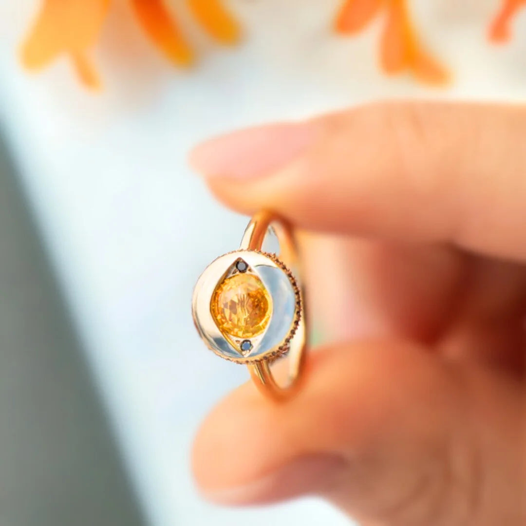 Yellow Sapphire Jubilee Ring with Black Accents and Artisan Design featuring a round Jubilee-cut yellow sapphire, black accent stones, gold ring setting, straight shank band, and handcrafted artisan styling.